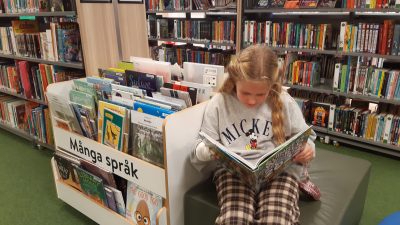 Elsie läser en bok i biblioteket